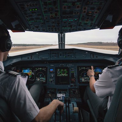 Cockpit-Ansicht von innen über die Schultern der Piloten