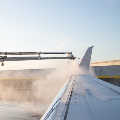 Maschine bei der Enteisung der Tragflächen eines Flugzeuges