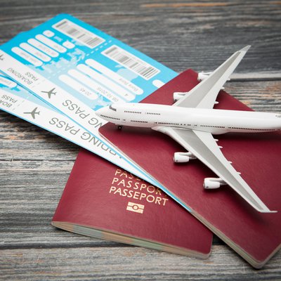 Reisepass mit zwei Flugtickets und Miniatur-FLugzeug