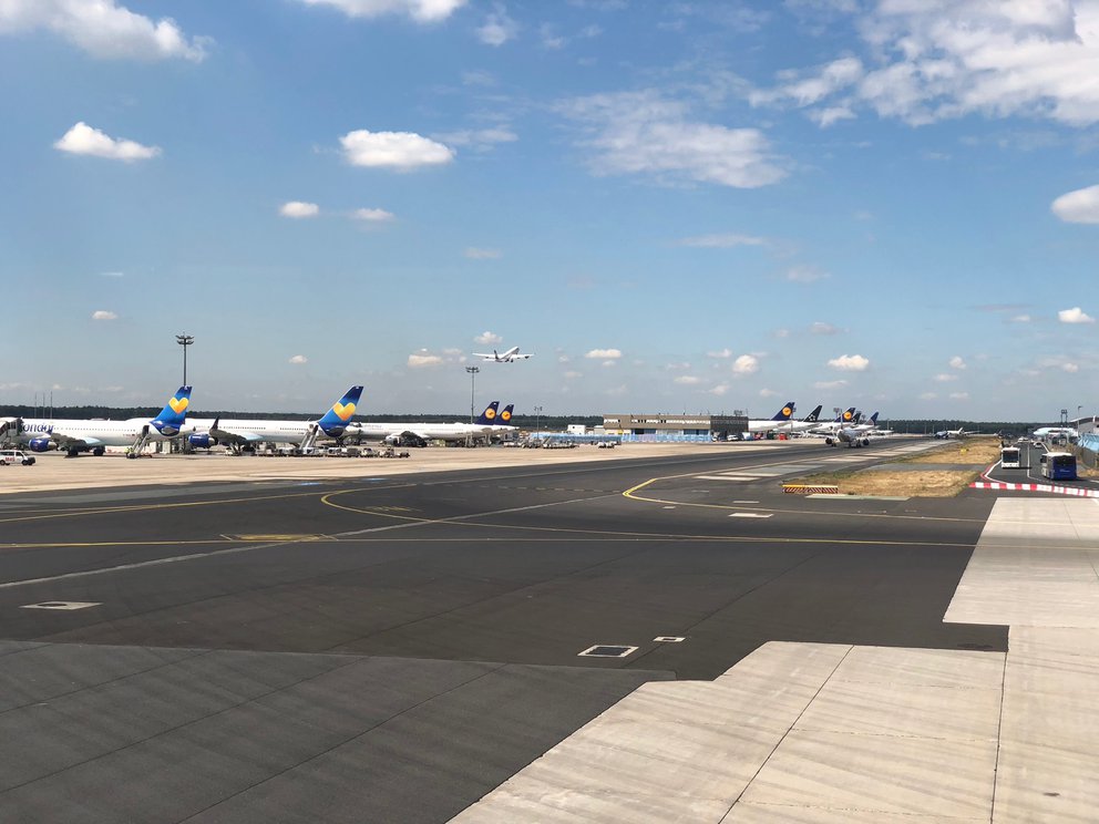 Flugfeld mit geparkten Maschinen am Rand