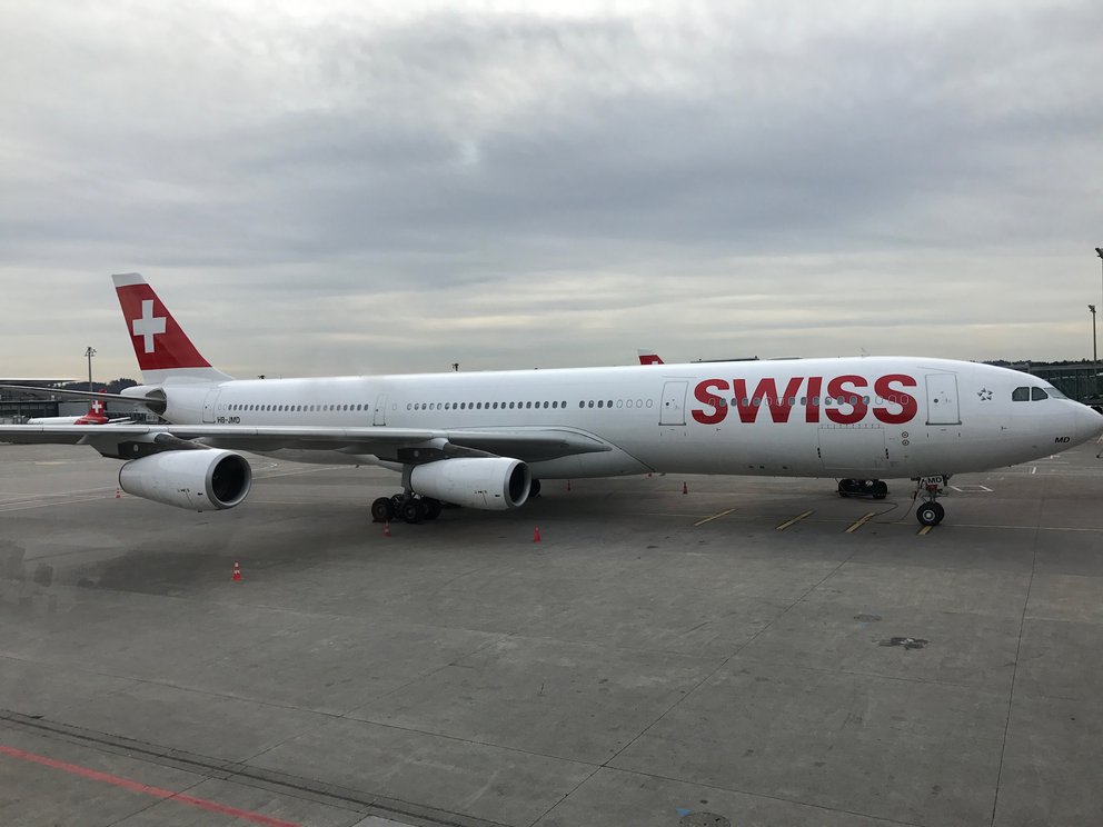 Flugzeug von Air Swiss vor bewölktem Himmel auf dem Rollfeld