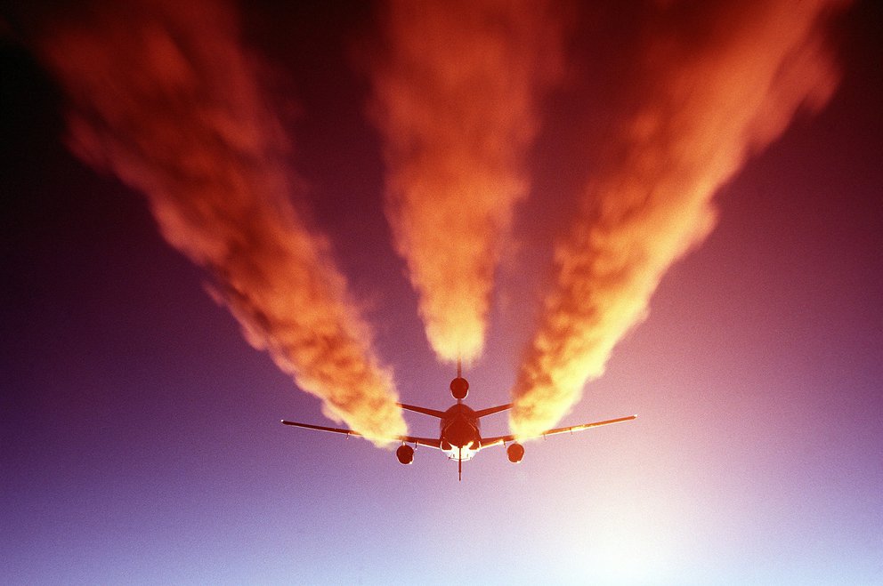 Rote Abgase eines Flugzeugs - Kondensstreifen
