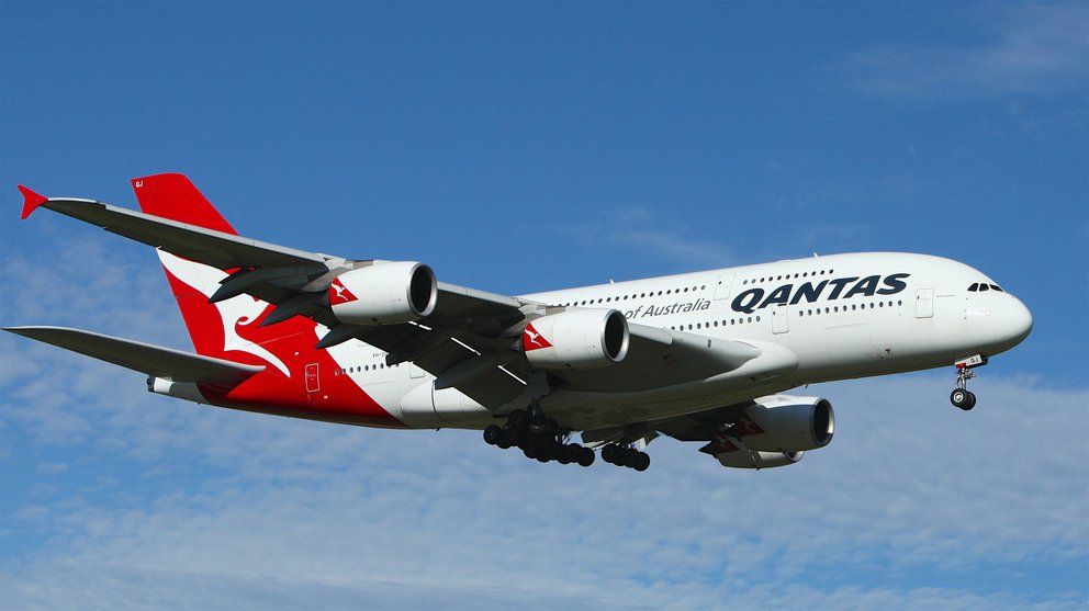 Qantas Maschine durchfliegt leicht bewölkten Himmel