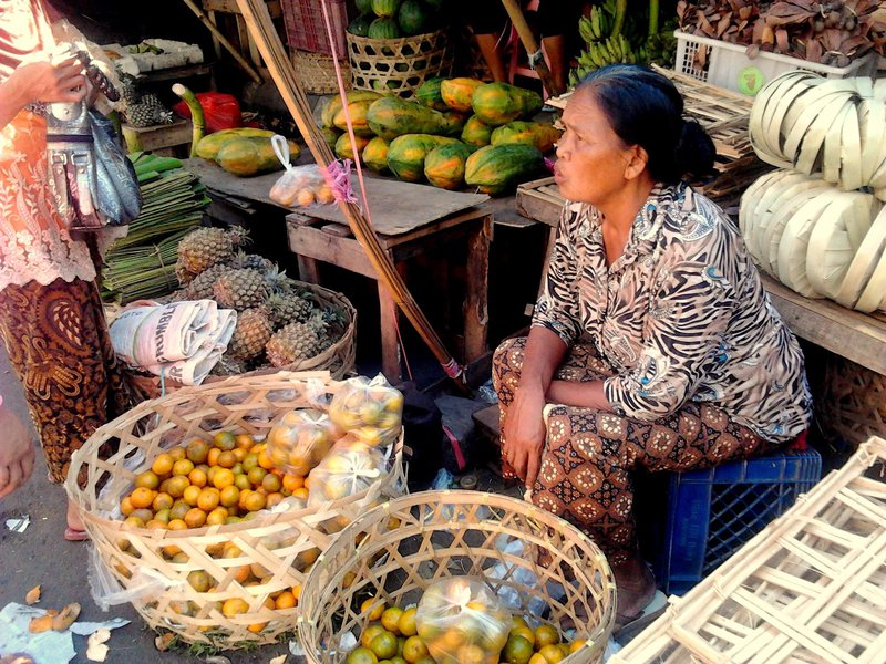 Eine Frau bietet ihr Obst auf Markt an