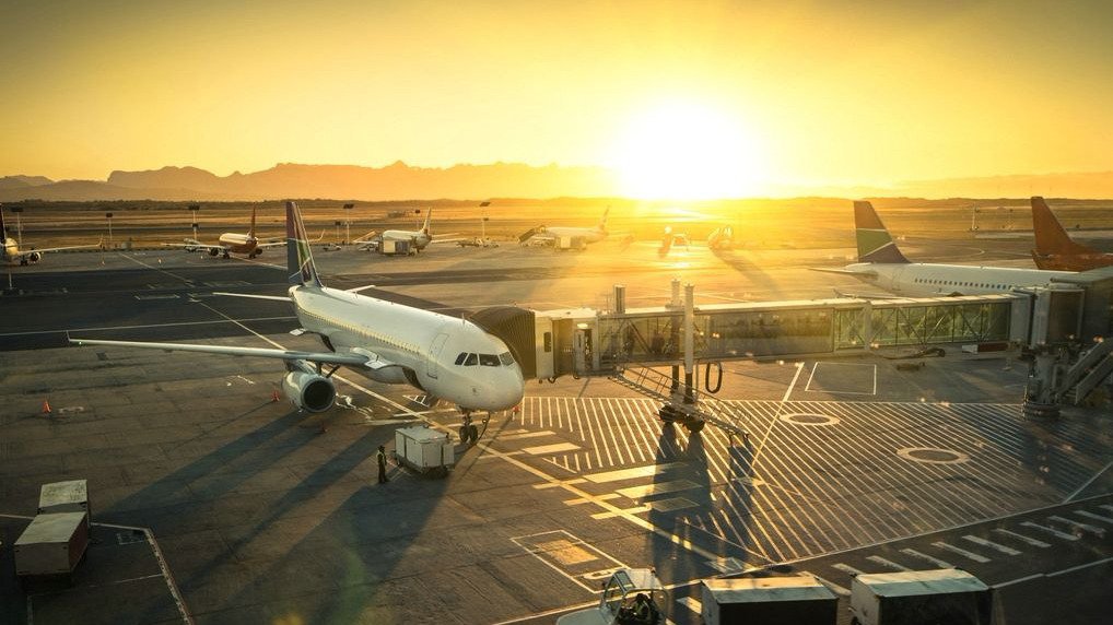 Flugfeld eines Flughafens mit mehreren Maschinen während des Sonnenuntergangs