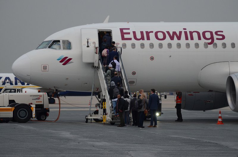 Fluggäste auf dem Rollfeld steigen vorn in eine Eurowings-Maschine ein