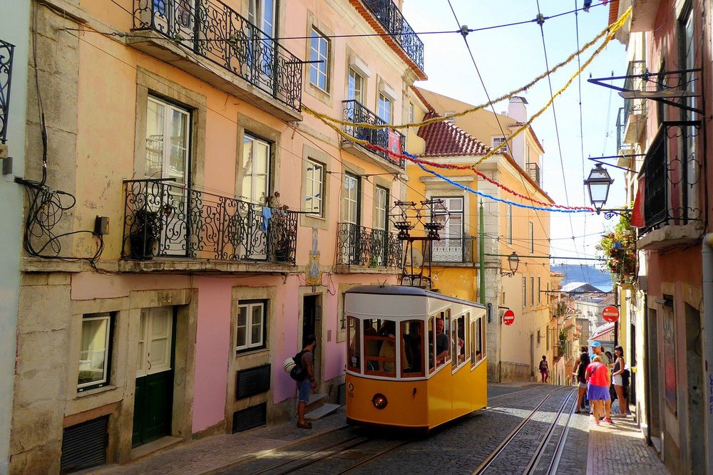 Gelbe Straßenbahn in einer Gasse in Lissabon