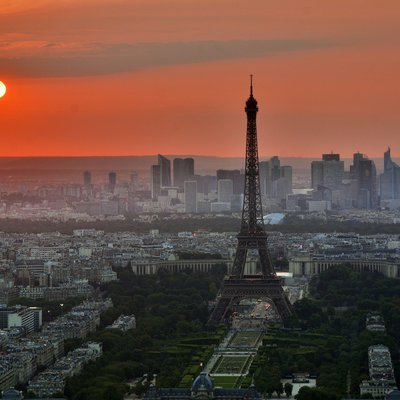 Paris Skyline mit Eiffelturm unter einer roten Sonne in der ABenddämmerung