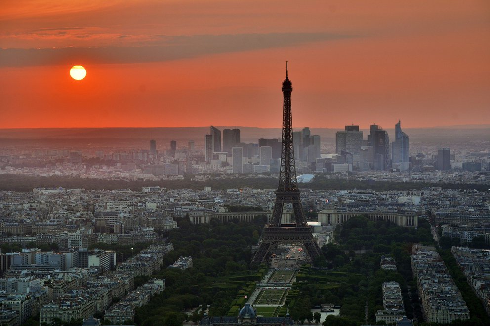 Paris Skyline mit Eiffelturm unter einer roten Sonne in der ABenddämmerung