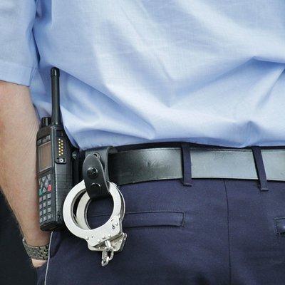 Polizeibeamter mit Handschellen und Pistole