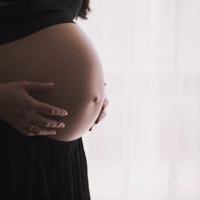 Schwangere Frau zeigt ihren Bauch